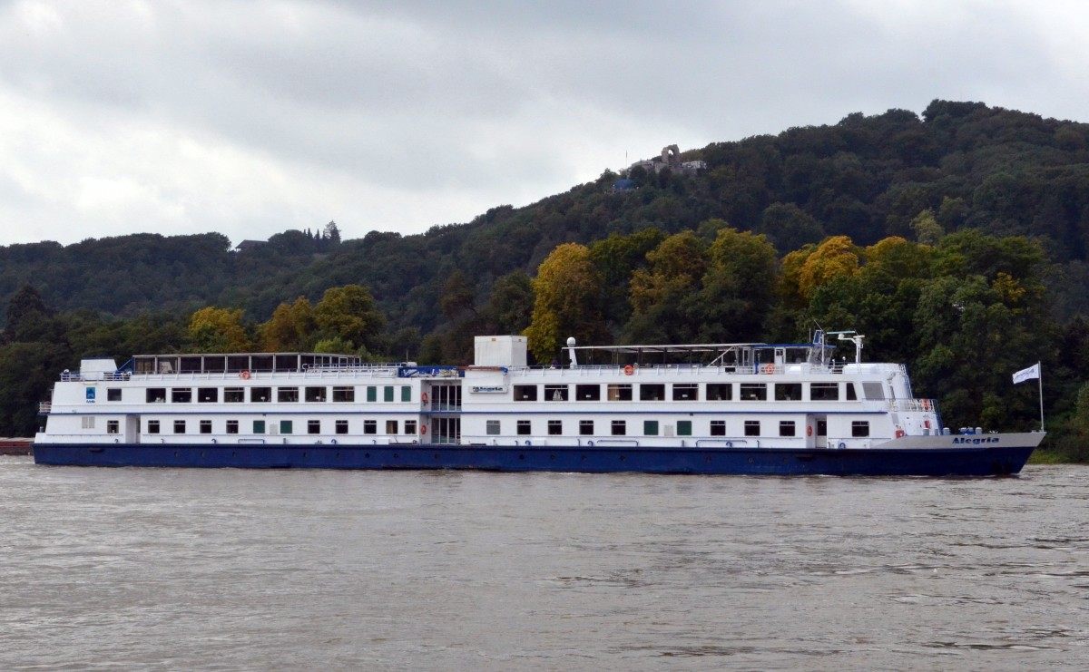River cruise ship sailing past forested hills